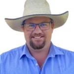 Headshot of Joe Wilks, AWN Wilks McKean (Wagga) Stock & Station/Real Estate Agent, smiling and wearing a straw hat and glasses.