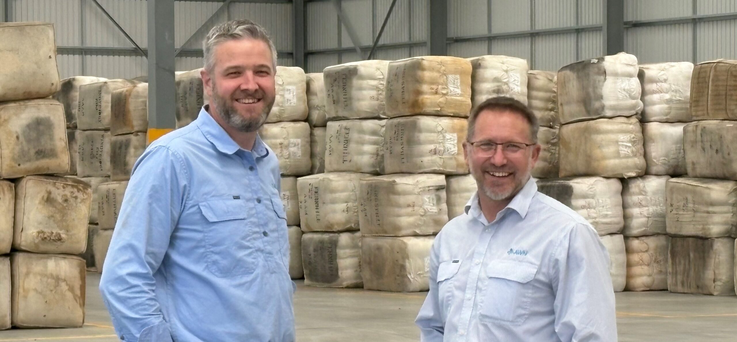 AWN's Managing Director & CEO Rick Maybury and Wool & Livestock State Manager Greg Tilbrook smiling in the new Bibra Lake warehouse, which streamlines wool handling for Western Australian woolgrowers.