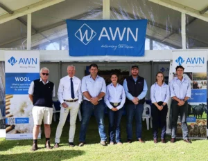 The AWN South Australian team standing outside on a sunny day at a field day event, with a white tent structure and parked cars in the background.